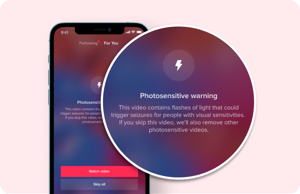 iPhone 10 with magnified image of TikTok's photosensitivity warning message.